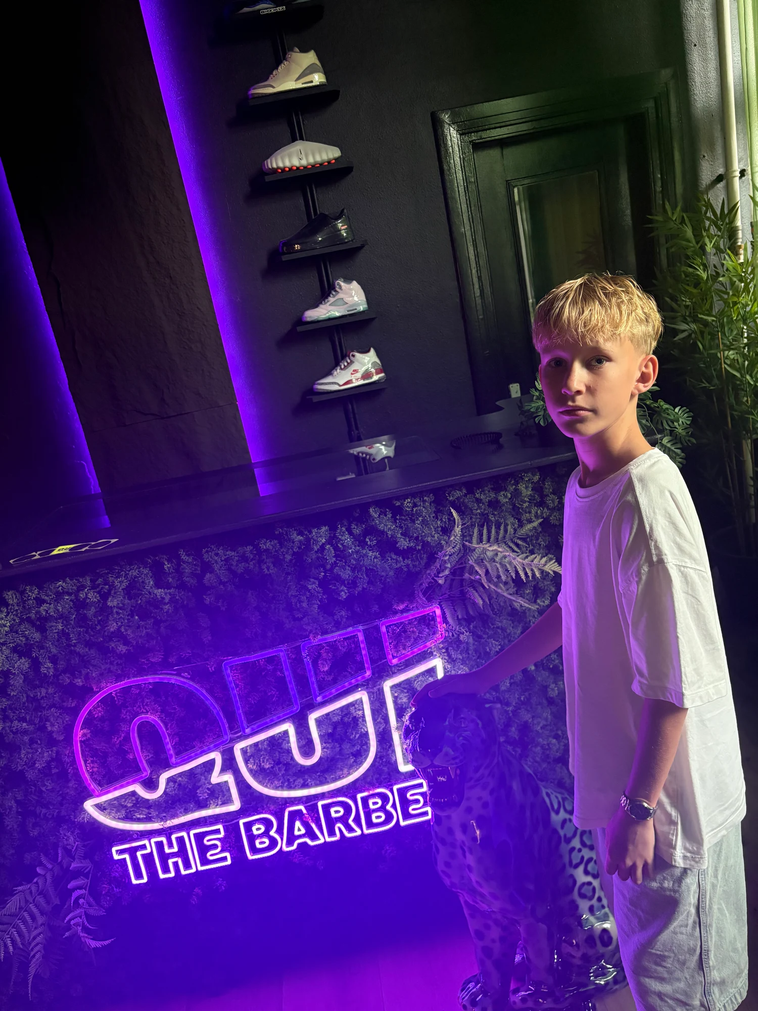 Klant naast de balie met het verlichte Qui the Barber-logo