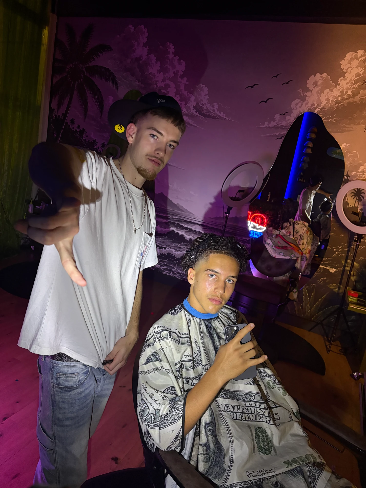 Barbier naast een klant in de stoel bij Qui the Barber